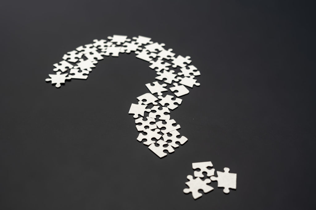 closeup puzze question mark on dark background isolated